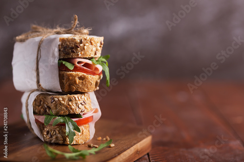 Homemade sandwiches prepared with fresh vegetables and olive oil on dark background