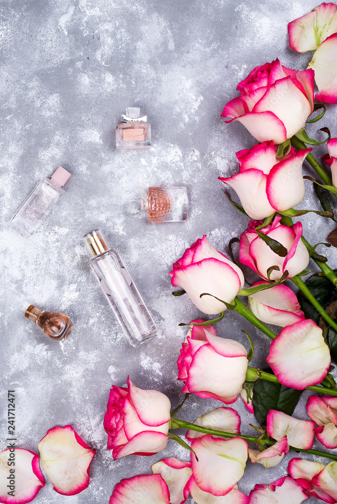 Floral frame composition with roses and many different perfume bottles on stone background. Flat lay, top view. Valentines day Floral frame composition with roses and many different perfume bottles on stone background. Flat lay, top view. Valentines day