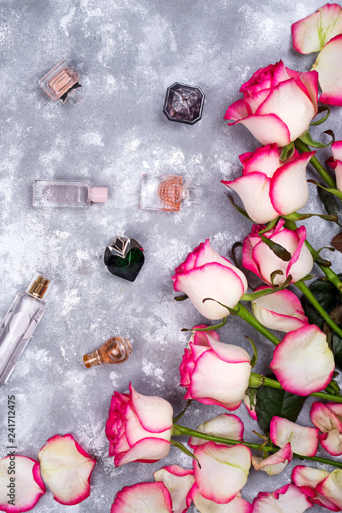 Floral frame composition with roses and many different perfume bottles on stone background. Flat lay, top view. Valentines day Floral frame composition with roses and many different perfume bottles on stone background. Flat lay, top view. Valentines day