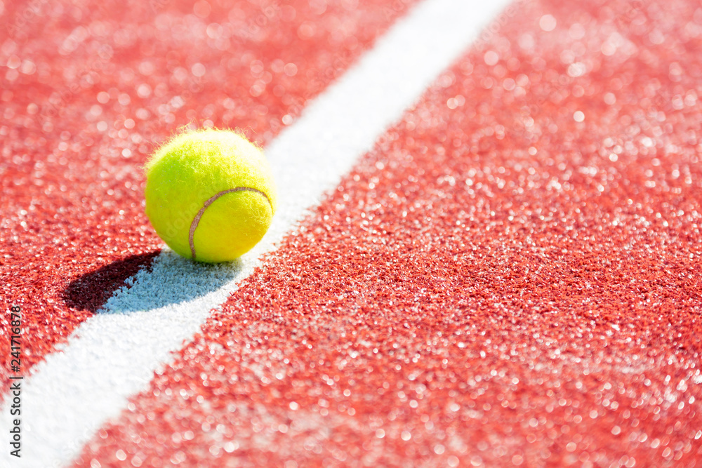 High angle view of tennis ball on red court during sunny day