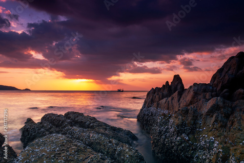 Long exposure image of Dramatic sky and wave seascape with rock in sunset scenery background © panya99