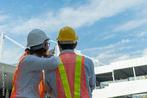 civil engineers wear personal protective equipment, one person pointing at something after project complete, partnership agreement ,teamwork together and business success. © alis
