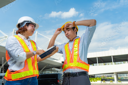 Male and Female Industrial and civil engineers wear personal protective equipment, discuss the end of project and working in project site.partnership agreement, teamwork and business concept,