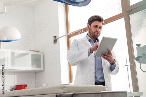 Veterinary doctor using digital tablet while standing at clinic