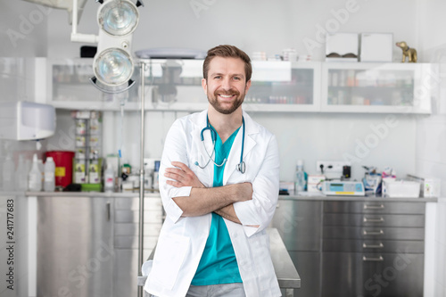 Portrait of smiling doctor standing with arms crossed at veterinary clinic photo