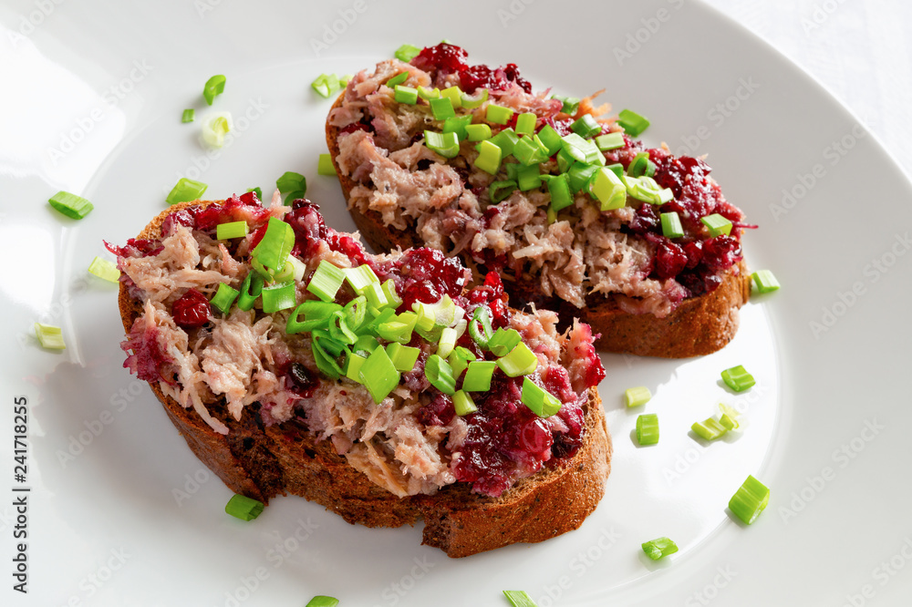 two open sandwiches with rabbit rillette and bog berry jam decorated with chopped green onion two open sandwiches with rabbit rillette and bog berry jam decorated with chopped green onion