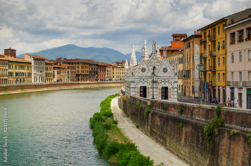 View on  Arno River in Pisa with gothic cathedral Santa Maria della Spina.