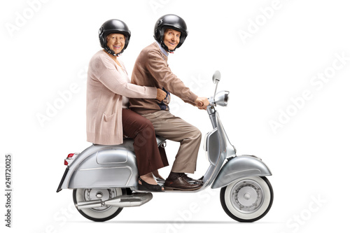 Senior couple with helmets riding on a vintage scooter