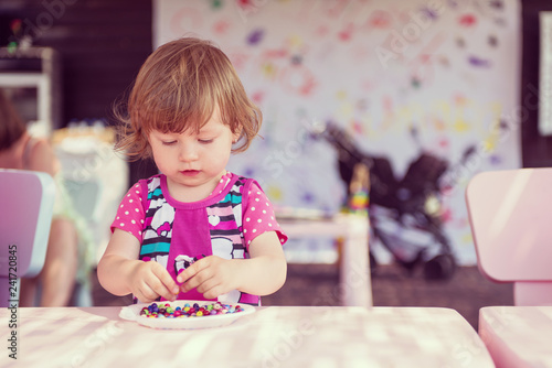 little girl drawing a colorful pictures