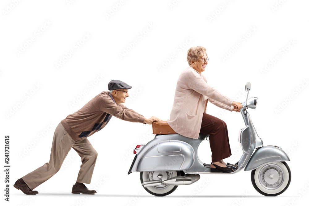 Fototapeta premium Starszy mężczyzna pchanie uśmiechnięta starsza kobieta jedzie na skuterze rocznika