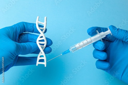 DNA helix research. Concept of genetic experiments on human biological code DNA. The scientist is holding DNA helix and syringe.