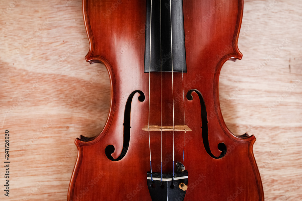 The classic violin put on wooden board,show front sideof acoustic instrument The classic violin put on wooden board,show front sideof acoustic instrument