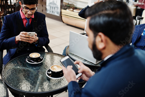 Photography Group of indian business man in suits sitting at office on cafe with laptop, texting on phones and making photo of coffee
