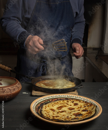 man in an apron fries pancakes