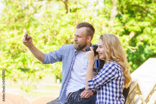 Man and woman taking photos with a camera and a smartphone. © Acronym