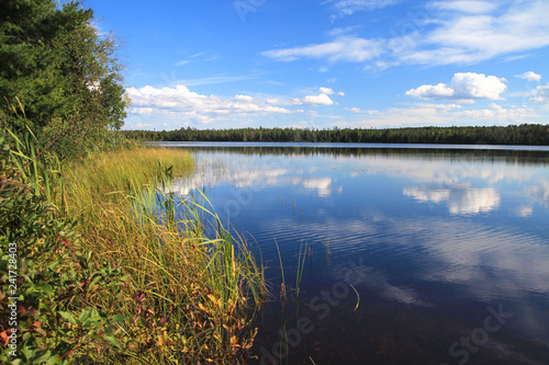 Northern Michigan Wilderness Lake. Sunny blue sky and clouds reflected at a beautiful remote inland lake in the Hiawatha National Forest of the Upper Peninsula.