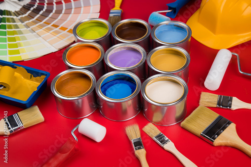 Collection of colored paints cans, Brush, red background
