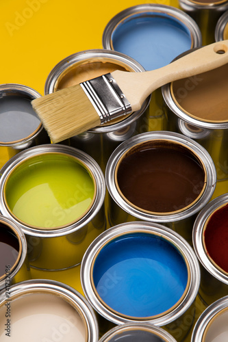 Tin cans with paint, brushes and bright palette of colors