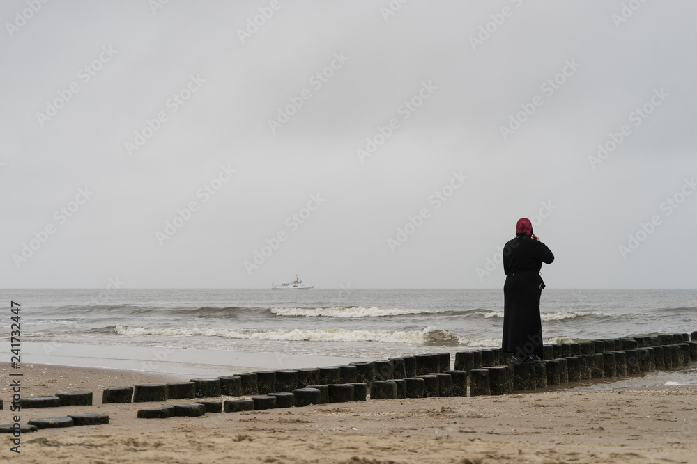 freau mit rotem kopftuch auf einer bune am strand von ahlbeck auf usedom  Stock Photo | Adobe Stock