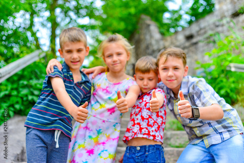 Three brothers and sister stand on the steps in the park and show the class.