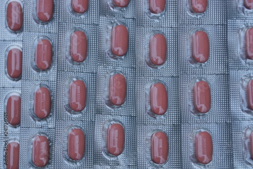 gray blister texture with lots of brown pills in pack photo