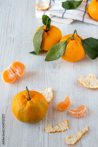 Fresh ripe tangerines on white wooden background, side view.