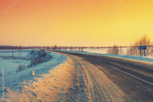 Winding winter road at sunrise. Winter rural landscape