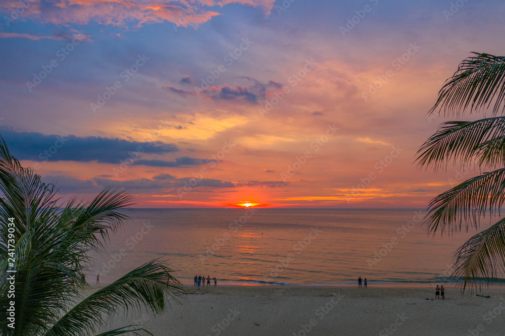 beautiful sunset over coconut trees at Karon beach Phuket