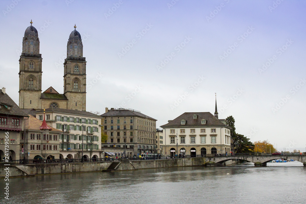 ZURICH, SWITZERLAND - OCT 130th, 2018: View of Grossmunster and Zurich old town from Limmat river. The Grossmunster is a Romanesque Protestant church in Zurich, Switzerland. Rainy weather in autumn.