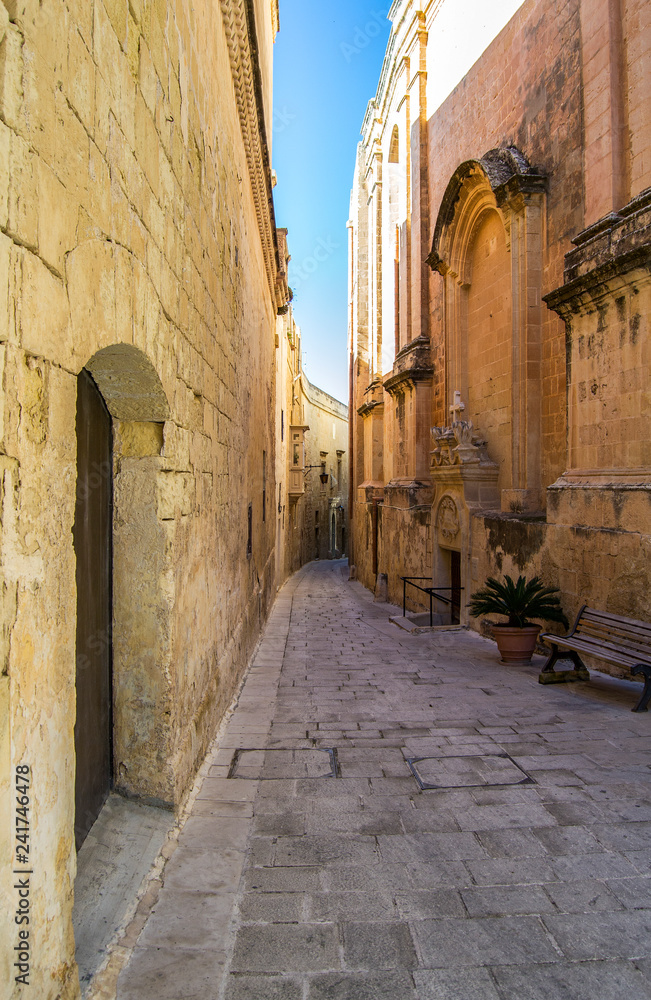 Mdina, Malta, old town narrow street with yellow stone buildings