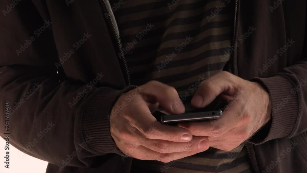 Casual male is texting message on mobile phone indoors, close up of hands Casual male is texting message on mobile phone indoors, close up of hands