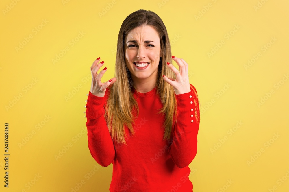 Young blonde woman annoyed and angry in furious gesture on yellow background Young blonde woman annoyed and angry in furious gesture on yellow background