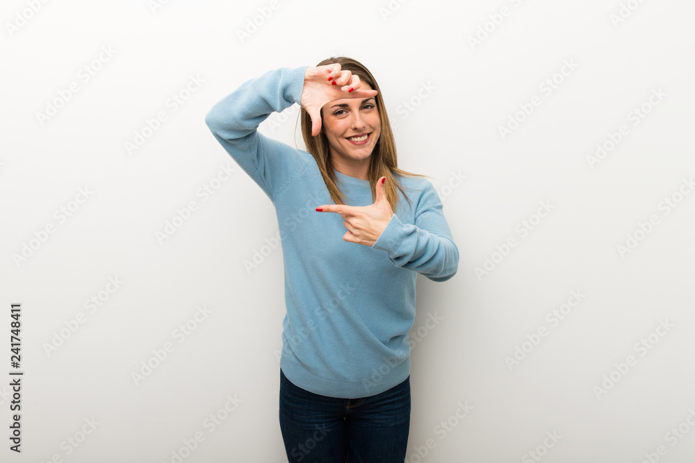 Fototapeta premium Blonde woman on isolated white background focusing face. Framing symbol