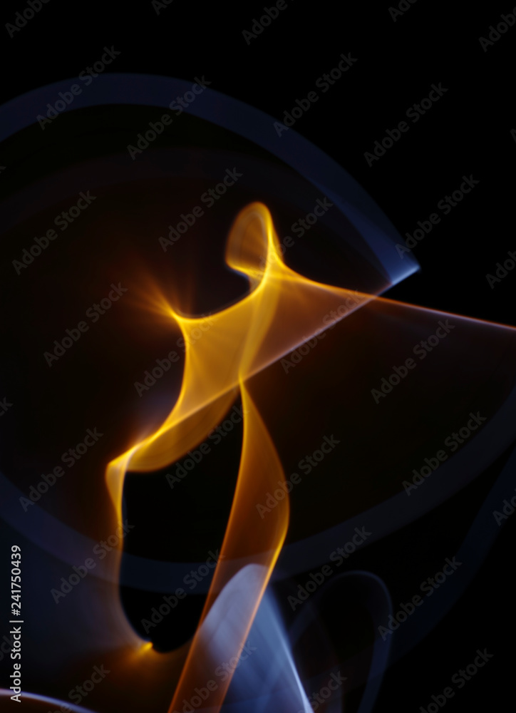 Fototapeta premium Orange-yellow-white curled line - ribbon painted by light on the black background. Improvisational painting by light.