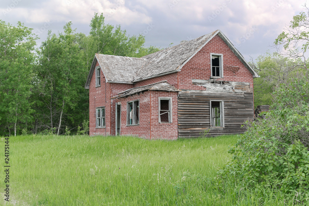 old abandoned farm house surrounded by green trees old abandoned farm house surrounded by green trees