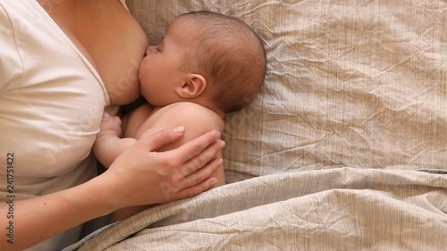 mother breastfeeding and hugging baby, close-up breast. Mom breast feeding her newborn child. Lactation infant. Baby eating milk before he sleeping. Mother feed her two month baby son with breast milk