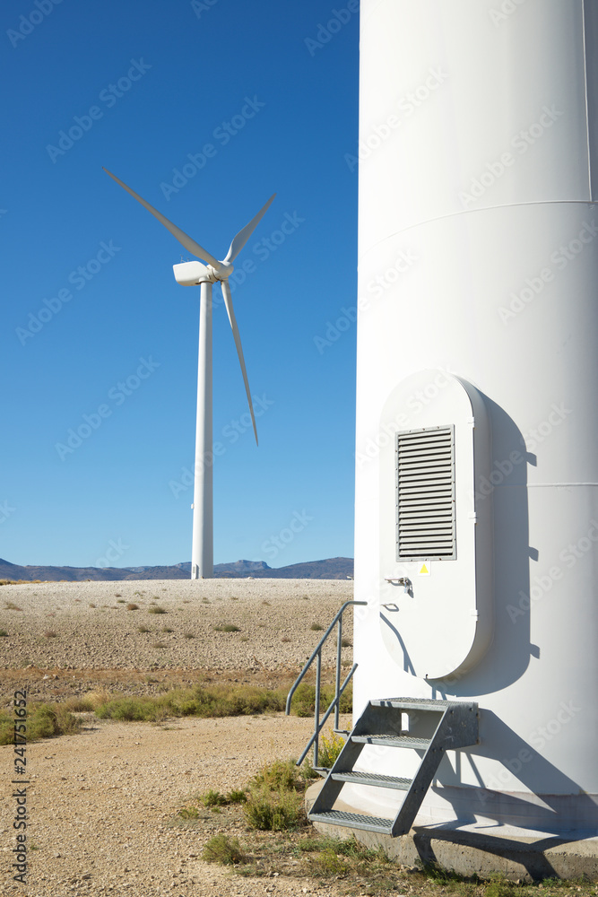Windmills on field against clear blue sky Windmills on field against clear blue sky