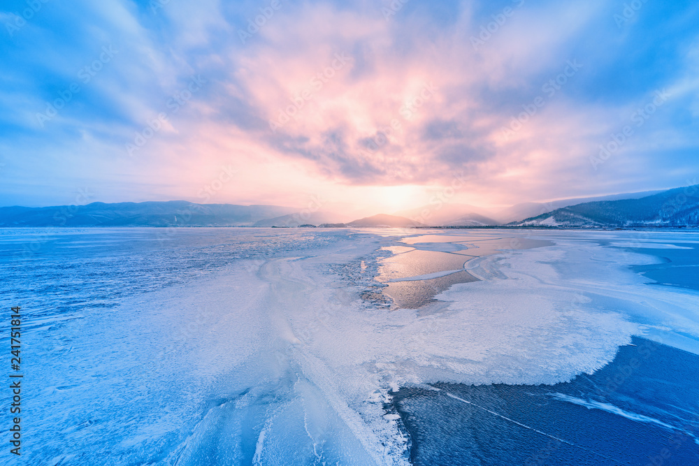 Fototapeta premium Frozen surface of Baikal lake at sunset.