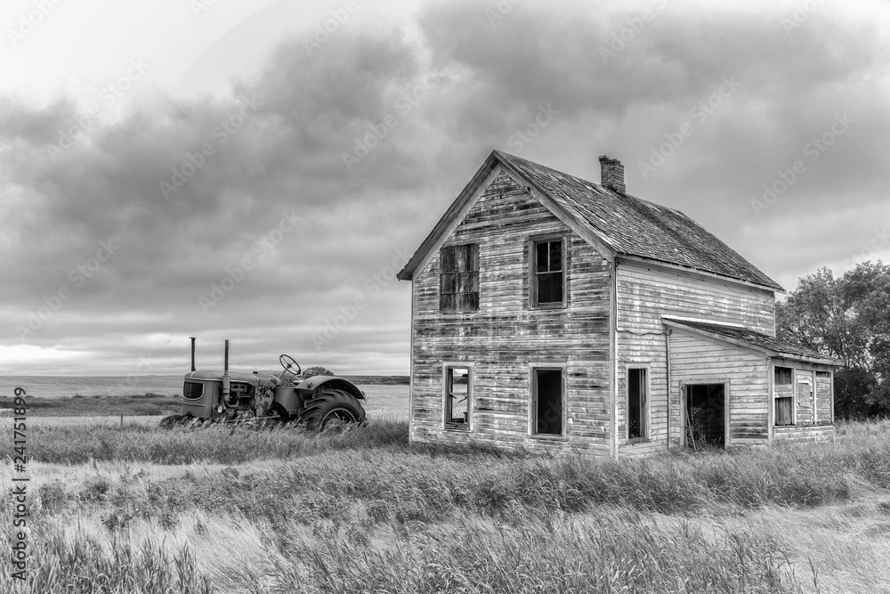 old farmhouse and tractor in black and white photo old farmhouse and tractor in black and white photo