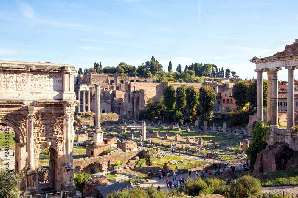 Lovely Roman Forum and Great Colosseum ( Coliseum, Colosseo, Flavian Amphitheatre ) in the evening. Picturesque urban landscape. Aerial panoramic view on famous touristic landmark in Rome, Italy.