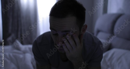 Depressed man in bed suffers from a symptom insomnia photo