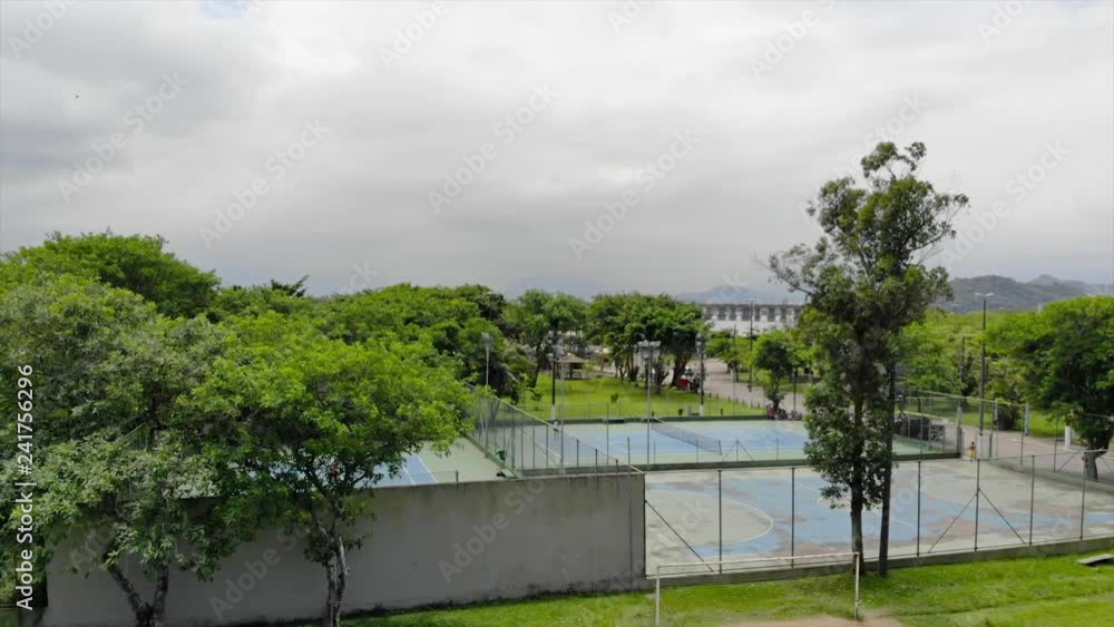 View of Tennis Courts Surround by Trees - Moving Towards View of Tennis Courts Surround by Trees - Moving Towards