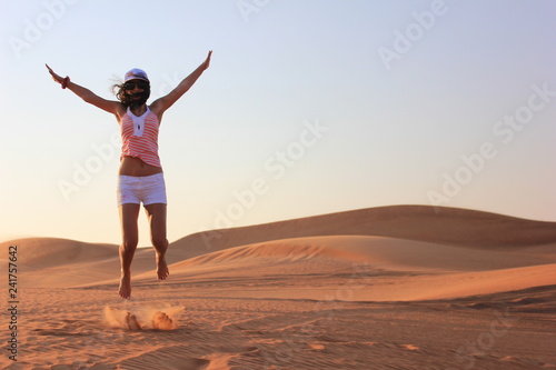 young woman jumping on the desert