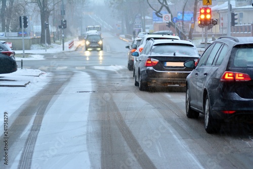 Fototapeta Naklejka Na Ścianę i Meble -  Cars standing in row in traffic jam on city street on slippery snowy road in winter