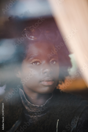 Portrait of girl looking through window