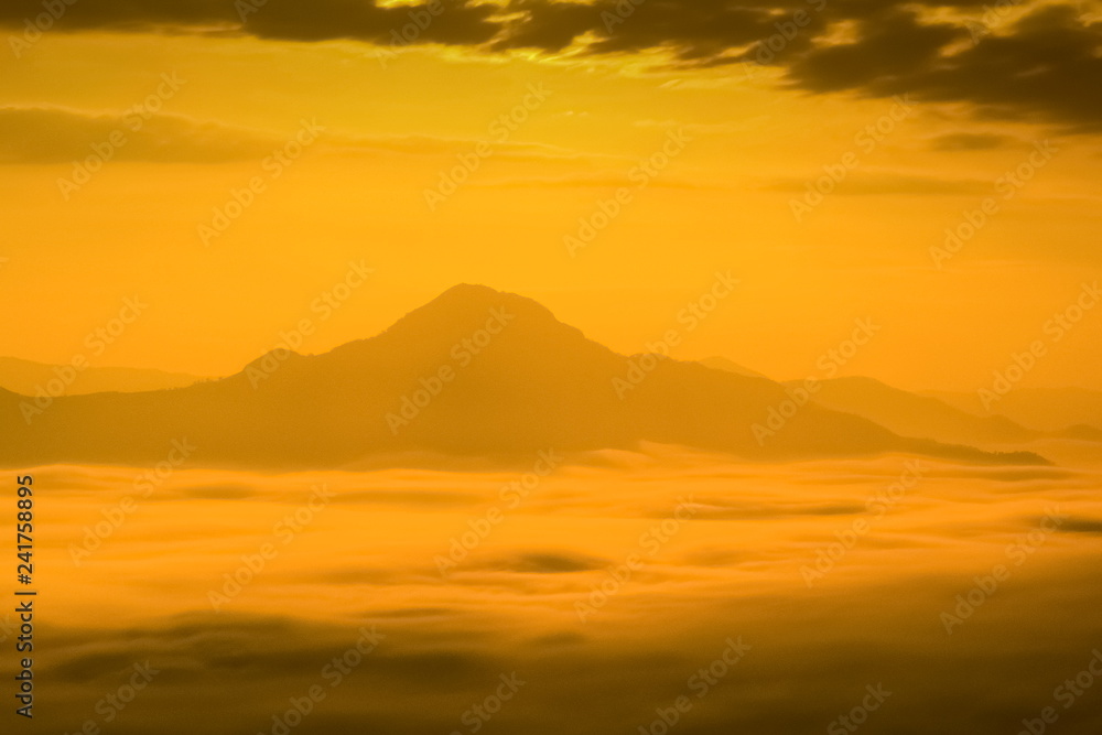 Mountain view misty morning of the hill around with the sea of mist with colorful yellow sun light in the sky background, sunrise at Phu Thok or Phu Tok, Chiang Khan District, Loei, Thailand.