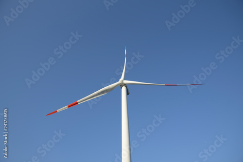 Wind turbine on blue sky. Production of clean and renewable energy. Trentino, Italy