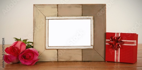Photo frame, rose flower and gift boxes on a table