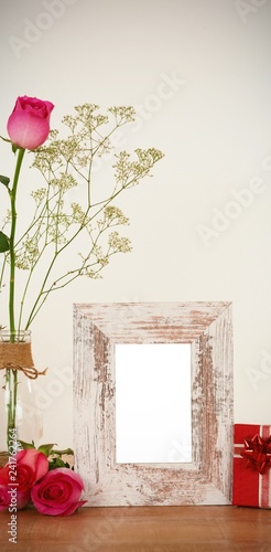 Rose flower in glass vase, photo frame and gift box