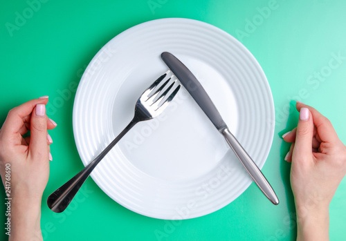 plate fork knife stop on green background, top view, flat lay